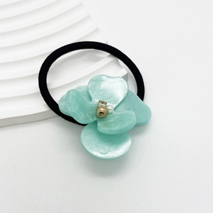 Detail of mint green resin flower hair tie with pearl bead and black elastic band