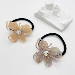 Detail of marble pattern acetate butterfly hair ties with iridescent gemstone center