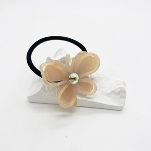 Detail of pink acetate butterfly hair tie with central rhinestone on white stone