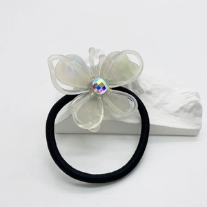 Close-up of translucent butterfly hair tie with iridescent crystal on white background