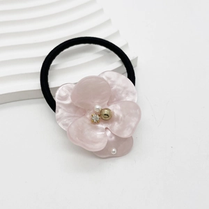 Detail of pink resin flower hair tie with marble texture, pearls, and crystals