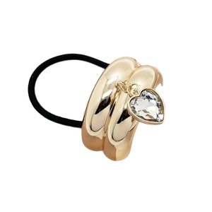 Golden U-shaped metal hair tie with heart crystal pendant on black elastic band