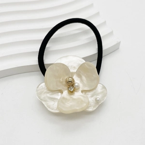 Close-up of acetic acid flower hair tie with pearl texture and crystal center detail