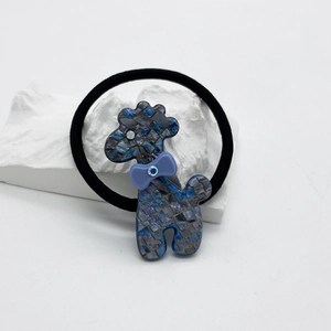 Détail d'élastique chien caniche bleu avec motif mosaïque, nœud mauve et strass