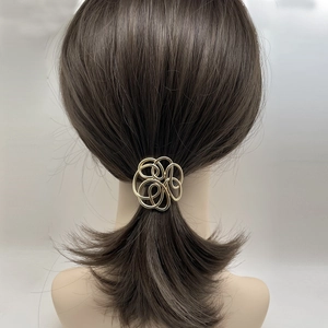 Rear view of gold geometric intertwined metal hair hook on an elegant low ponytail