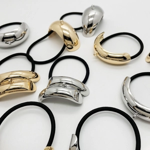 Elastici per capelli in lega a forma di U, finiture oro e argento lucido su sfondo bianco