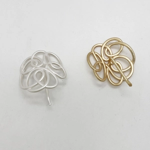 Detailed close-up of hollow spherical geometric metal hair hooks in gold and silver finishes