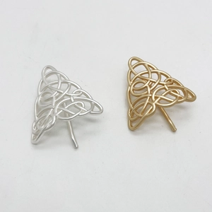 Close-up of gold and silver Celtic knot triangle hair forks in a minimalist metal design