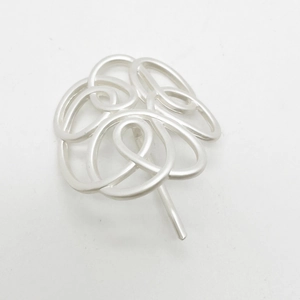 Detailed view of silver-colored alloy hair pin with abstract floral wire design and metal pin