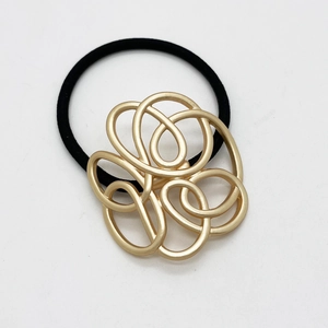Minimalist geometric gold metal hair hook with black elastic band on white background