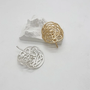 Makroansicht minimalistischer hohler kreisförmiger Haarnadeln aus Legierung in Gold und Silber