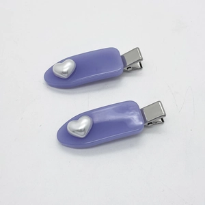 Détail de barrettes en résine violette translucide avec accents métalliques coeur argenté