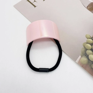 Detail view of the pink U-shaped hair tie with glossy finish on a minimalist white background