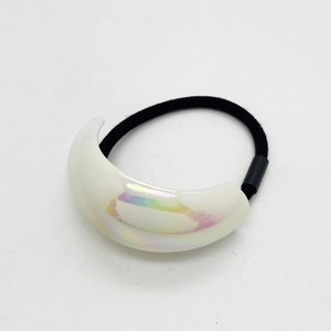 Macro detail of U-shaped white iridescent acrylic accessory on elastic hair band