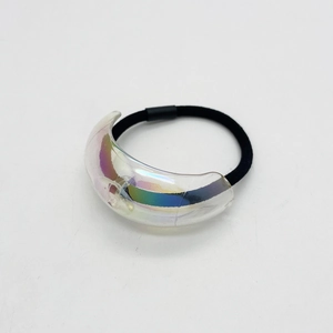 Close-up of black elastic hair tie featuring an iridescent acrylic crescent charm decoration