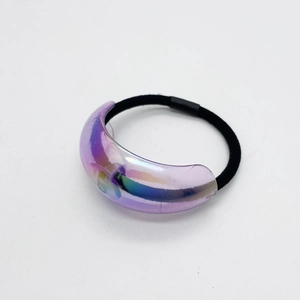 Detail of laser iridescent crescent acrylic piece on a black elastic hair tie