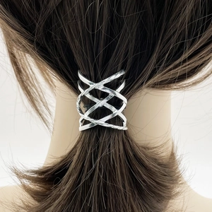 Detailed view of silver hollow woven metal ponytail clip on dark brown hair