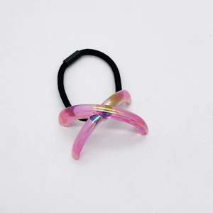 Détail d'un élastique à cheveux noir avec un charm en acrylique rose irisé en forme de X