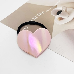 Détail d'un chouchou cœur rose avec finition perle irisée sur une page de magazine
