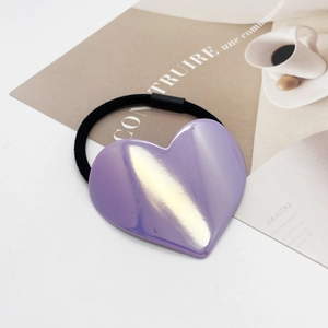Gros plan d'un grand cœur en acrylique violet sur un élastique à cheveux en nylon noir