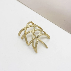 Detail showing gold hollow woven ponytail clip with intersecting metal lines and matte finish