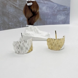 Detail of bicolor gold and silver C-shaped hair clip with textured molten metal finish