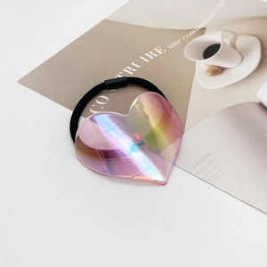 Gros plan sur un chouchou cœur rose iridescent sur un magazine de mode avec élastique noir