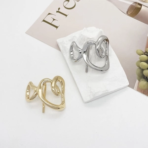 Minimalist hollow heart metal hair clips in gold and silver finish on a stylish prop