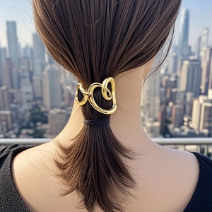 Golden minimalist metal hair clip with abstract twisted design on a low ponytail