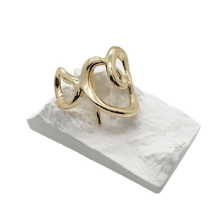 Minimalist gold alloy hollow hair hook with abstract heart design on white stone stand