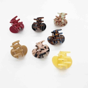 Set of mini heart-shaped acetate hair claws in various marble colors and floral patterns
