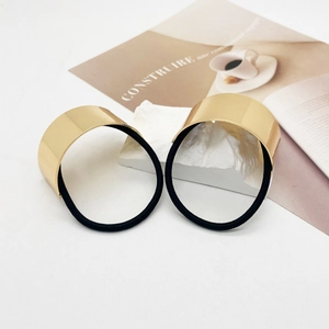 Close-up of golden minimalist U-shaped metal hair ties with premium mirror finish
