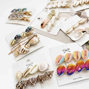 Starfish shell hair clip set with pearls and resin patterns on display card