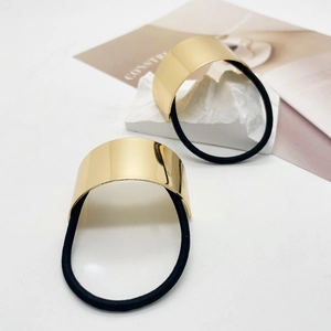 Close-up of minimalist U-shaped gold metal buckle with high-elastic black hair tie