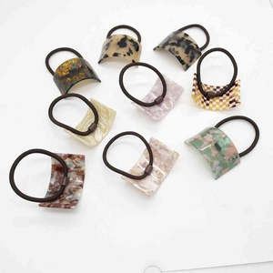 Detail of diverse acetate hair ties with leopard, marble, and checkered patterns