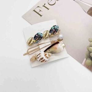 Detail of Korean ocean hair clip set featuring seashell and pearl designs on a white card