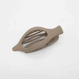 Detailed view of a matte brown hollow shuttle-shaped hair clip for women's hairstyles