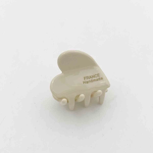 Detailed macro view of small cream acetate hair claw clip with France Handmade text
