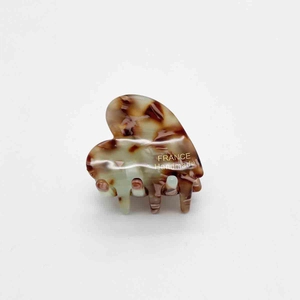 Detailed macro of tortoise shell heart hair claw with gold France Handmade lettering