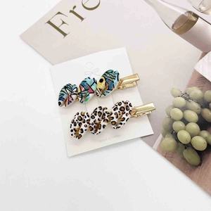 Close-up of shell hair clips with colorful marble and leopard print patterns