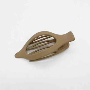 Detailed macro view of matte camel brown resin hair clip with inner gripping teeth