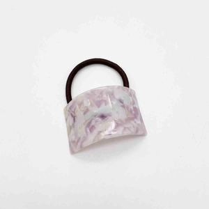 Detailed close-up of purple marble patterned acetate decoration on dark brown hair tie