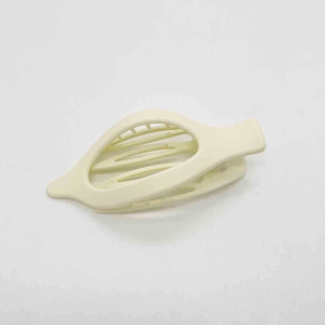 Detailed view of cream-colored matte leaf-shaped hair clip with hollow geometric design