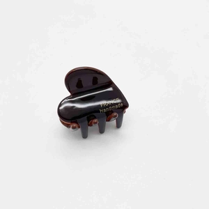 Detail view of small heart-shaped brown tortoiseshell hair claw with gold handmade text
