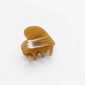Detailed macro view of amber acetate heart hair claw with France Handmade text