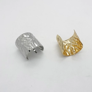 Close-up of gold and silver ponytail hooks with hammered liquid metal texture finish