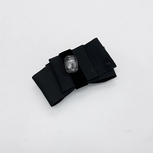 Detailed macro view of the double-layered black grosgrain bow hair clip with gray crystal