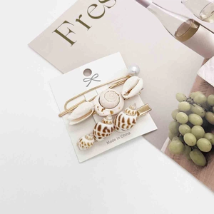 Detail of seashell and starfish hair clips set with pearls on a display card