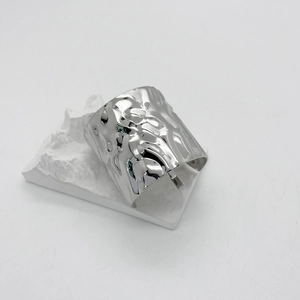 Macro detail of silver ponytail hook featuring a unique hammered liquid metal texture