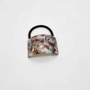 Detail shot of the U-shaped acetate marble pattern hair tie with durable black elastic band